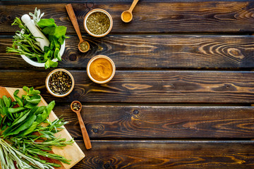 Wall Mural - Making spices. Herbs in motar and dry flavorings on dark wooden desk top-down copy space