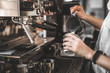 © ArdichawatSripaiboo - barista pouring hot coffee in machine