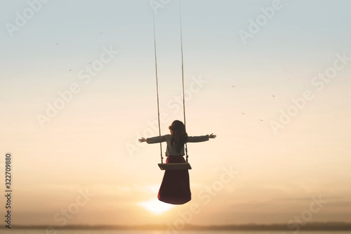 Fotomural special contact between nature and a woman with open arms on a swing