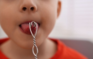 Canvas Print - Little boy doing exercise with logopedic probe at speech therapist office, closeup