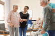 Care workers helping to elderly patients to walk in geriatric hospice