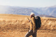 © Mediteraneo - Senior man on hike through beautiful countryside in autumn.