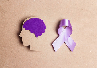 Wall Mural - Purple awareness ribbon and brain symbol on a brown background.