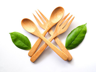 Wall Mural - Wooden spoon and fork and green leaf, Natural wooden utensils isolated on white background.