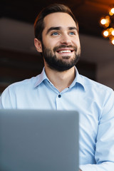 Sticker - Portrait of young businessman using laptop while working in office