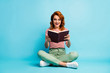 © deagreez - Full length photo of crazy book worm woman sit floor rest relax cross legs read book impressed scream wow omg wear white green footwear pants isolated blue color background