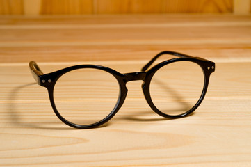 Glasses with black plastic frames and lenses. Background for a healthy vision. Unisex universal glasses.