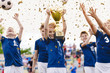 © matimix - Champion youth soccer team with winning trophy. Boys football team celebrating victory in school competition by rising up golden cup. Happy kids as soccer tournament winners