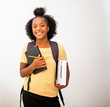© mimagephotos - african american teenage girl student holding  bag and books