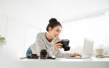 Portrait Of Beautiful Asian Photographer Woman Working Home Office Holding Camera With Laptop. Business People Employee Freelance Online Marketing.  Successful Freelance Creative Artist Girl Business