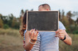 © shchus - Lovers man and woman are holding a wooden sign for inscriptions and dates. Photography, concept.