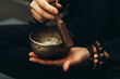 Close-up of hands with rosary playing on singing bowls. Relaxation and meditation. Alternative medicine. Tibetan and Himalayan singing bowls. Make a sound.