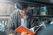 © Charnchai saeheng - A man hands opening and reading a book at library.