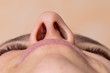 Nose of a woman seen from below. Laser hair removal concept of nose hair