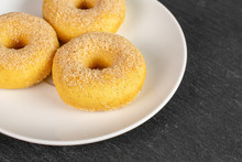 Group Of Three Whole Sweet Golden Mini Cinnamon Donut On White Ceramic Plate On Grey Stone