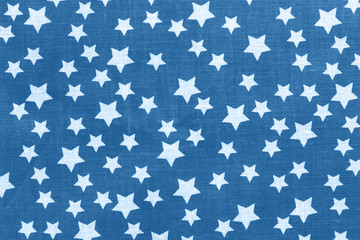 Classic blue stars on black canvas cotton texture. Dark colored fabric background