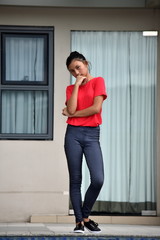 Wall Mural - Thinking Young Filipina Girl Standing By Condo