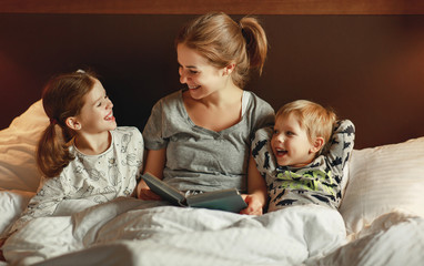 Wall Mural - evening family reading. mother reads children . book before going to bed .