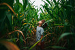 © RooM The Agency - Portrait of a boy standing in a corn field looking up at the sky, USA
