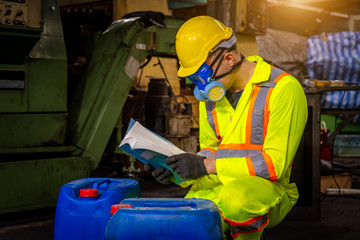 A Engineer industry wearing safety uniform ,black gloves and gas mask under checking chemical tank in industry factory work.