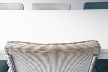 Wall Mural - Empty white wooden dining table with modern chairs in white room, closeup