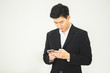 © eakgrungenerd - asian businessman sitting using smartphone telephone online working in office.