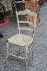 old wooden chair on a sidewalk in a street market