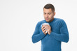 © InsideCreativeHouse - Young man feeling sick with cup on white background