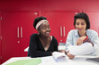© Sam Edwards/Caia Image - Female community college students discussing paperwork in classroom