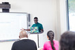 © Sam Edwards/Caia Image - Male community college instructor at projection screen in classroom