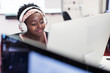 © Sam Edwards/Caia Image - Smiling female community college student headphones at computer