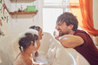 © Trevor Adeline/Caia Image - Playful father giving toddler daughters bubble bath