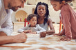 © Trevor Adeline/Caia Image - Young family playing scrabble word game at table
