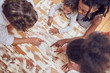 © Trevor Adeline/Caia Image - Young family playing scrabble word game at table