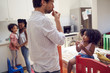 © Trevor Adeline/Caia Image - Young family eating fruit in kitchen