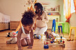 © Trevor Adeline/Caia Image - Pregnant mother and daughter playing with toys