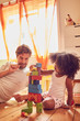 © Trevor Adeline/Caia Image - Father and daughter playing with wood blocks