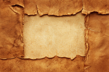 Wall Mural - Four old crumpled torn ancient sheets of paper on another vintage sheet of paper form a rectangular frame with copy space.