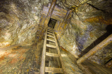 Old gold mine underground vertical shaft bottom view with stairs ladders