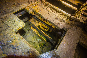 Old gold mine underground vertical shaft top view with stairs ladders