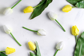 Canvas Print - Floral pattern made of yellow and white tulip on marble background. Flat lay, top view. Holiday background.