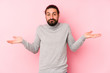 © Asier - Young long hair man isolated on a pink background doubting and shrugging shoulders in questioning gesture.
