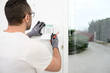 © W PRODUCTION - handsome man worker installing alarm technology insurance in home for burglar prevention