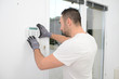 © W PRODUCTION - handsome man worker installing alarm technology insurance in home for burglar prevention