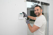 © W PRODUCTION - handsome man worker installing alarm technology insurance in home for burglar prevention