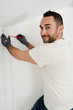© W PRODUCTION - handsome man worker installing alarm technology insurance in home for burglar prevention