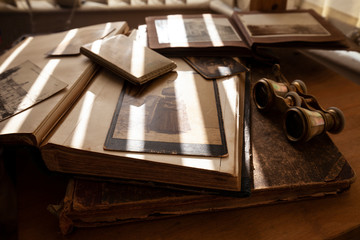 Wall Mural - Old photos, books, album, binoculars, cigarette case in shallow deep of field.