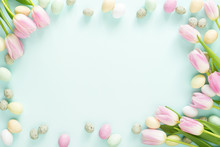 Colored Easter Candy Eggs And Pink Tulips On Turquoise Background. Easter Frame.