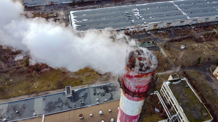 Aerial view at industrial heating station smoking pipe in the winter at sunset. View of pipes with smoke after burning natural gas.