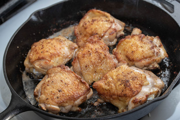 Wall Mural - cooking chicken thigh on iron skillet